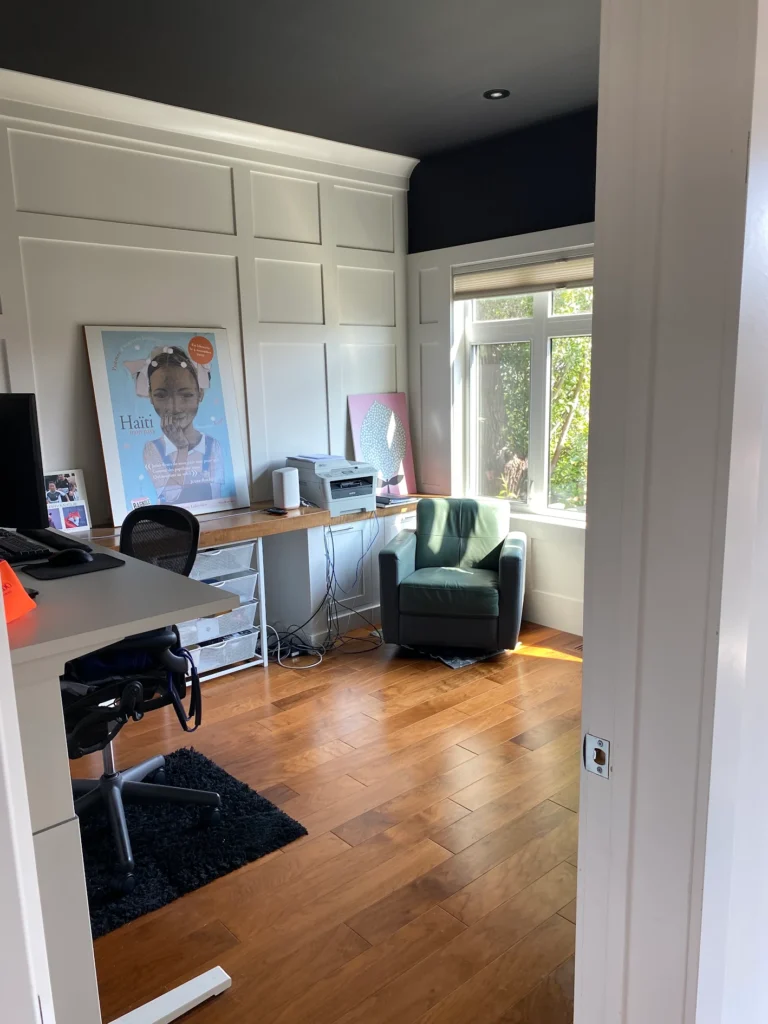 Home office with a green chair and hardwood floor